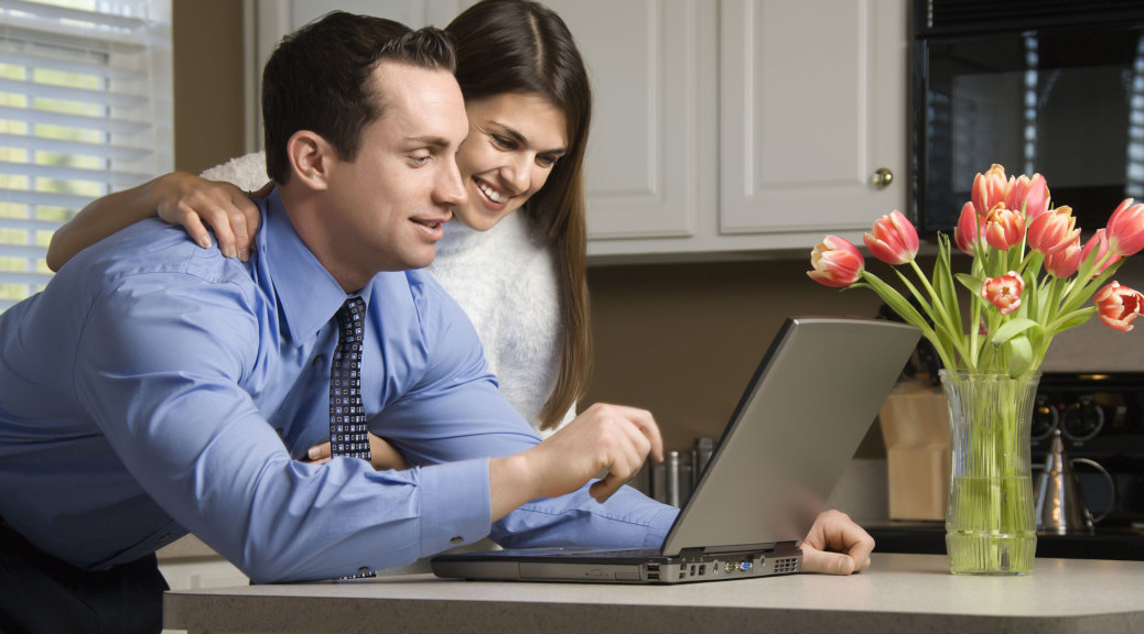couple looking at a laptop in the kitchen